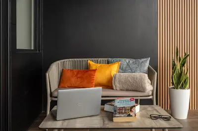 a couch with pillows and a laptop on a table at ÉWA Homes Monteverde in Monteverde Costa Rica
