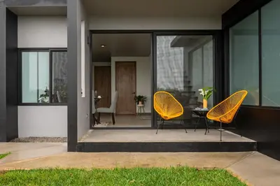 two chairs and a table on the front of a house at ÉWA Homes Monteverde in Monteverde Costa Rica