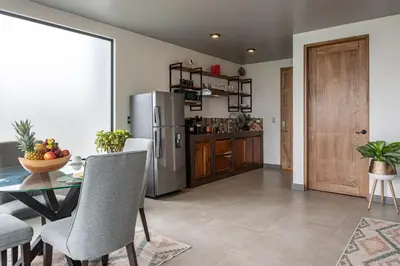 a kitchen and dining room with a table and a refrigerator at ÉWA Homes Monteverde in Monteverde Costa Rica