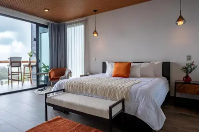 a bedroom with a king sized bed and a balcony at ÉWA Homes Monteverde in Monteverde Costa Rica