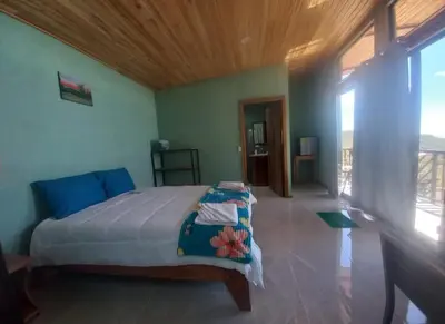 a bedroom with a large bed with a wooden ceiling at Cabina el atardecer in Monteverde Costa Rica
