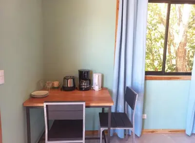 a table and chairs in a room with a window at Cabina el atardecer in Monteverde Costa Rica