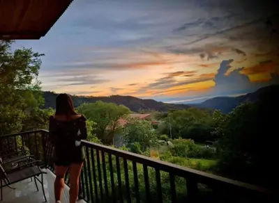 a woman walking on a balcony looking at the mountains at Cabina el atardecer in Monteverde Costa Rica