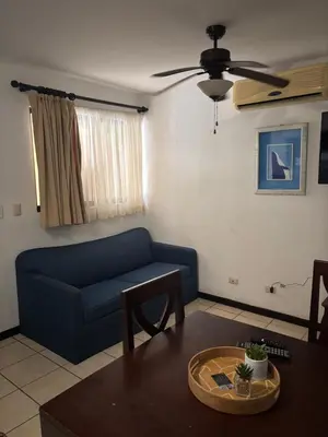 a living room with a blue couch and a table at Cocomarindo 63 in Coco