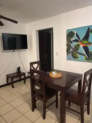 a dining room with a table and chairs and a tv at Cocomarindo 63 in Coco