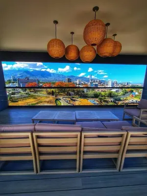 a large tv with a large screen in a room at Top-floor overlooking uptown with AC & parking in San José