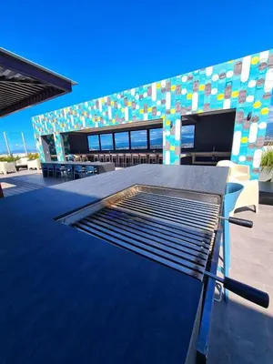a building with a grill in front of it at Top-floor overlooking uptown with AC & parking in San José