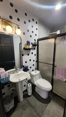 a bathroom with a toilet and a sink at Tropical Noir at Family Lodge in Jabillos