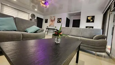 a living room with two couches and a table at Tropical Noir at Family Lodge in Jabillos