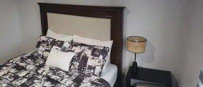 a bed with a black and white comforter and pillows at Tropical Noir at Family Lodge in Jabillos