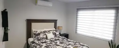 a bedroom with a bed and a window at Tropical Noir at Family Lodge in Jabillos