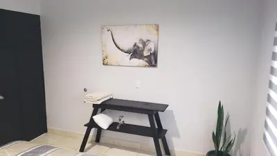 a desk in a room with an elephant painting on the wall at Tropical Noir at Family Lodge in Jabillos