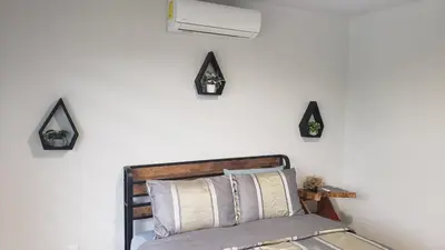 a bedroom with a bed with four black triangles on the wall at Tropical Noir at Family Lodge in Jabillos
