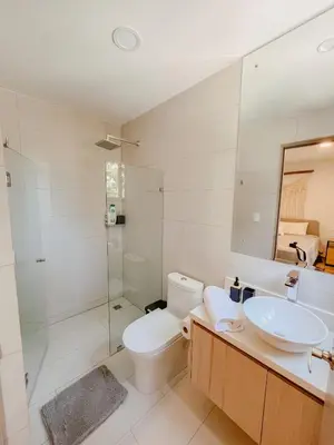 a bathroom with a toilet and a sink and a shower at Apartamento en condominio Torres del Mar, Jacó in Jacó