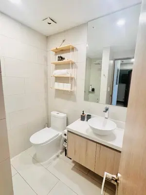 a bathroom with a toilet and a sink and a mirror at Apartamento en condominio Torres del Mar, Jacó in Jacó