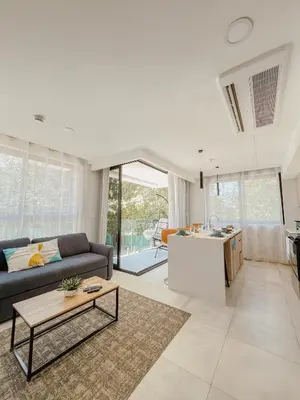 a living room with a couch and a table at Apartamento en condominio Torres del Mar, Jacó in Jacó