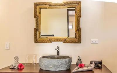 a bathroom with a stone sink and a mirror at Jardín de los Monos in Matapalo