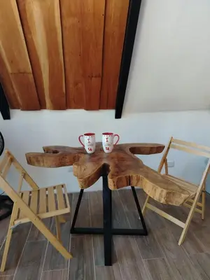 a wooden table with two cups and a chair at Angel View Alojamiento entero en Atenas in San Isidro