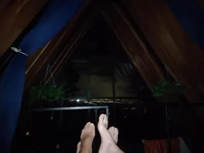 a persons feet on a window with a view of a city at Angel View Alojamiento entero en Atenas in San Isidro