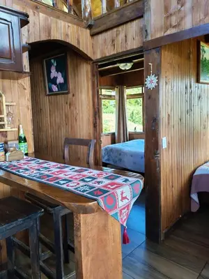 a dining room with a table and a bed at Cabaña Rancho Don Marino in Cartago