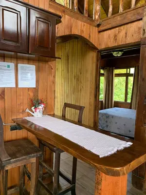 a dining room with a table and a bed at Cabaña Rancho Don Marino in Cartago