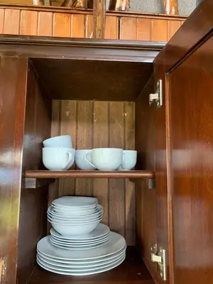 a cabinet with plates and bowls on a shelf at Cabaña Rancho Don Marino in Cartago