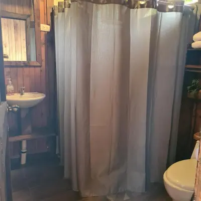 a bathroom with a shower curtain and a sink at Cabaña Rancho Don Marino in Cartago