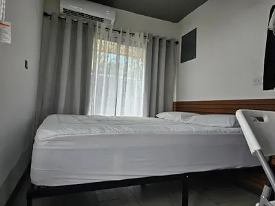 a bed in a room with a large window at Flatbirds Beautiful Small Apartment in San José Pinilla