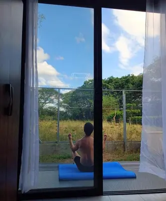 a man sitting in a window doing yoga at Flatbirds Beautiful Small Apartment in San José Pinilla