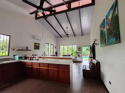a kitchen with wooden cabinets and a ceiling at La Finca Tovar- Casita in San Ramón