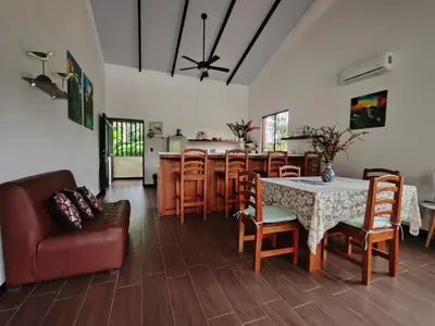 a living room with a table and chairs and a kitchen at La Finca Tovar- Casita in San Ramón