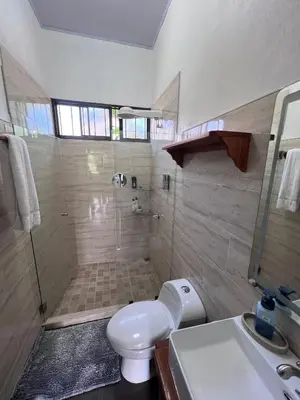 a bathroom with a shower and a toilet and a sink at La Finca Tovar- Casita in San Ramón