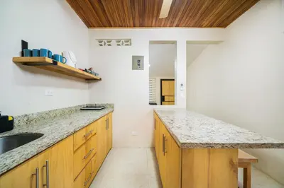 a kitchen with wooden cabinets and a counter top at Pequeno Paraiso - New Studio, 10min walk to Potrero beach, tranquil - Unit D in Potrero