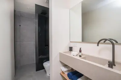 a bathroom with a sink and a toilet and a mirror at Villa Juba Tamarindo Centro in Tamarindo