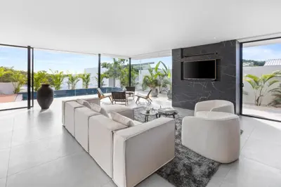 a living room with white furniture and large windows at Villa Juba Tamarindo Centro in Tamarindo