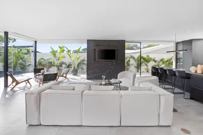 a living room with white furniture and a fireplace at Villa Juba Tamarindo Centro in Tamarindo