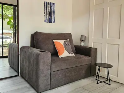 a brown couch with a pillow on it in a living room at Mystica Playa Avellanas in Playa Avellana