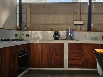 a kitchen with wooden cabinets and a counter top at Mystica Playa Avellanas in Playa Avellana