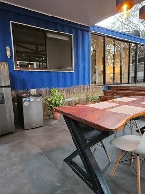 a dining room with a table and a blue wall at Mystica Playa Avellanas in Playa Avellana