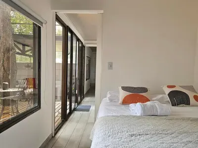 a bedroom with a bed and a large window at Mystica Playa Avellanas in Playa Avellana