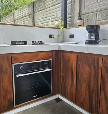 a kitchen with wooden cabinets and a stove top oven at Mystica Playa Avellanas in Playa Avellana