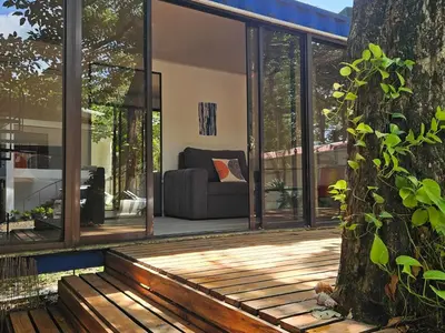 a house with glass doors and a tree at Mystica Playa Avellanas in Playa Avellana