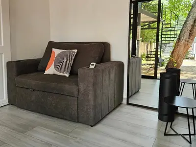a brown couch in a living room with a table at Mystica Playa Avellanas in Playa Avellana