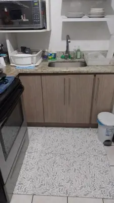a kitchen with a counter with a sink and a microwave at Rincón Metropolitano in San José
