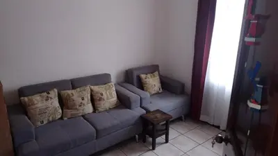 a blue couch with pillows in a living room at Rincón Metropolitano in San José