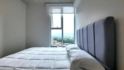 a bedroom with a large bed with a large window at Sabana Chic in Hatillo