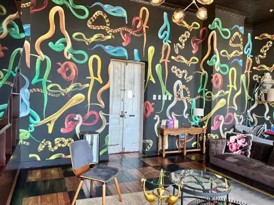 a living room with a colorful mural on the wall at Sabana Chic in Hatillo