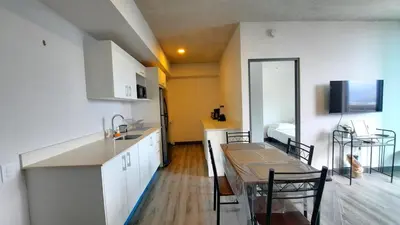 a kitchen with white cabinets and a table and chairs at Sabana Chic in Hatillo