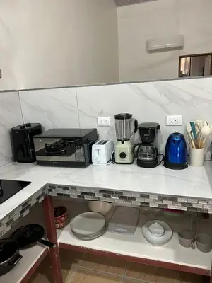 a kitchen with a counter with many appliances on it at Apartamento Quepos in Quepos