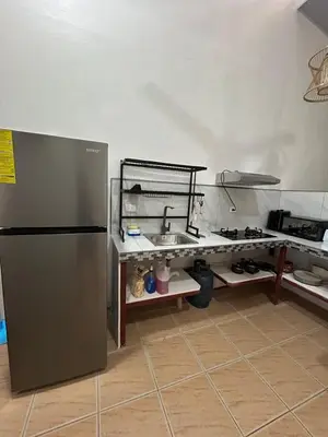a kitchen with a sink and a refrigerator at Apartamento Quepos in Quepos